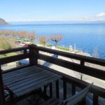 Balcon du studio avec petite table et deux chaises, vue dégagée sur le lac Léman à Saint-Gingolph